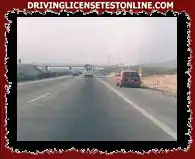 A fényképen látható piros jármű vezetője az autópálya jobb szélén kering, ezt...