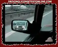 Attraverso il suo specchietto retrovisore osserva che un veicolo che lo segue fa lampeggiare le...