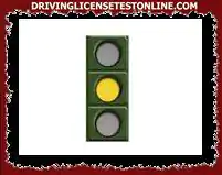 Driving your motorcycle, what should be your behavior before a fixed yellow traffic light ?