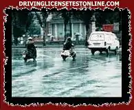 Vas conduciendo tu motocicleta y como se muestra en la imagen, el camino está mojado. Si frena, esta situación provocará. . .