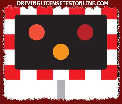 You are waiting at a railway crossing. Red warning lights continue to flash after a train passes near. What should you do ?