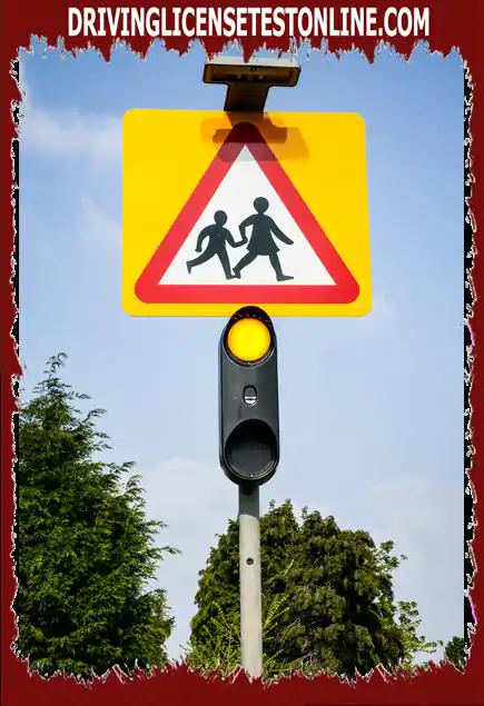 What action should you take when you see flashing amber lights below the school warning sign ?
