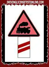 As shown in the picture, this sign is set at a guarded railway crossing, reminding the driver...