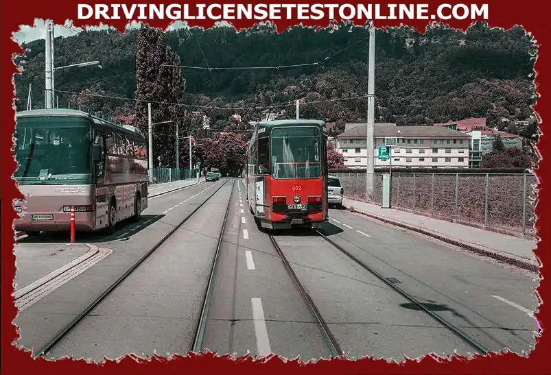 De tram rijdt rond de 20 km/u . Voertuigen staan ​​geparkeerd aan de rechterkant van de baan...