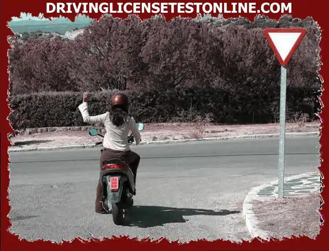 A cette intersection, la conductrice du cyclomoteur indique du bras qu'elle va